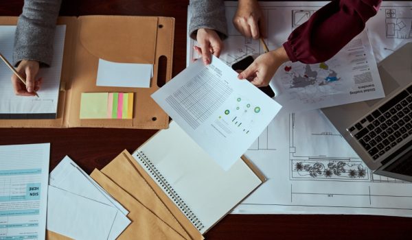 Professional designers working in modern office and making notes during active discussion